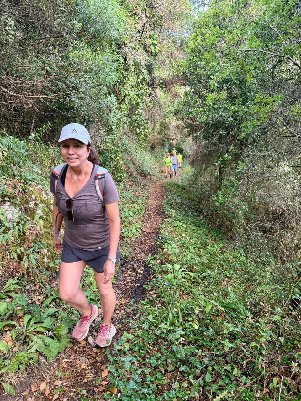 Woman hiking along one of the best hiking trails, surrounded by lush green forest.